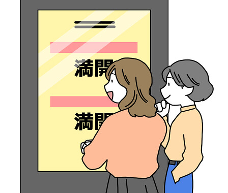 観光案内のデジタルサイネージを見ている2人の女性